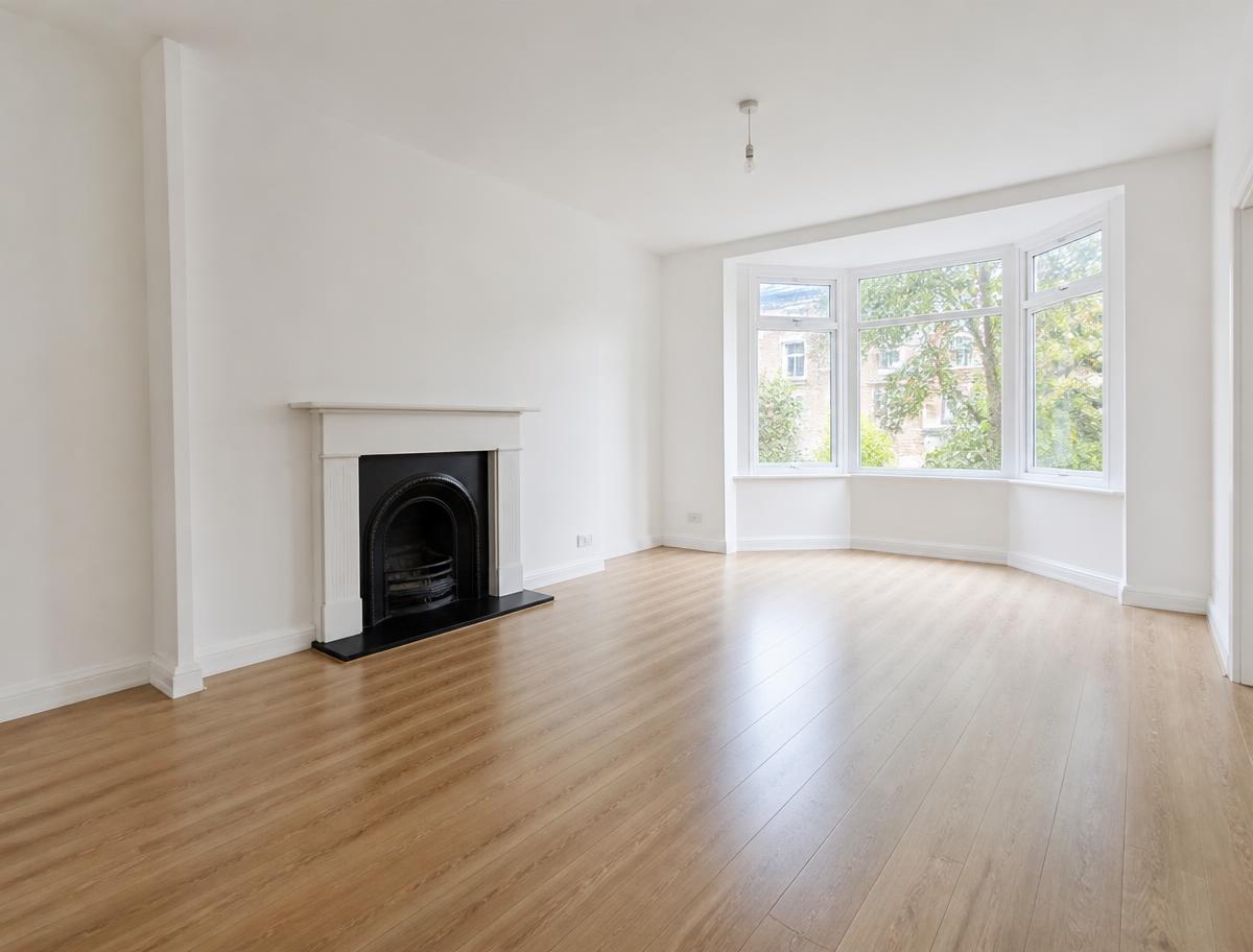 Leeres, besenrein gekehrtes Wohnzimmer mit Holzboden nach einer Entrümpelung.